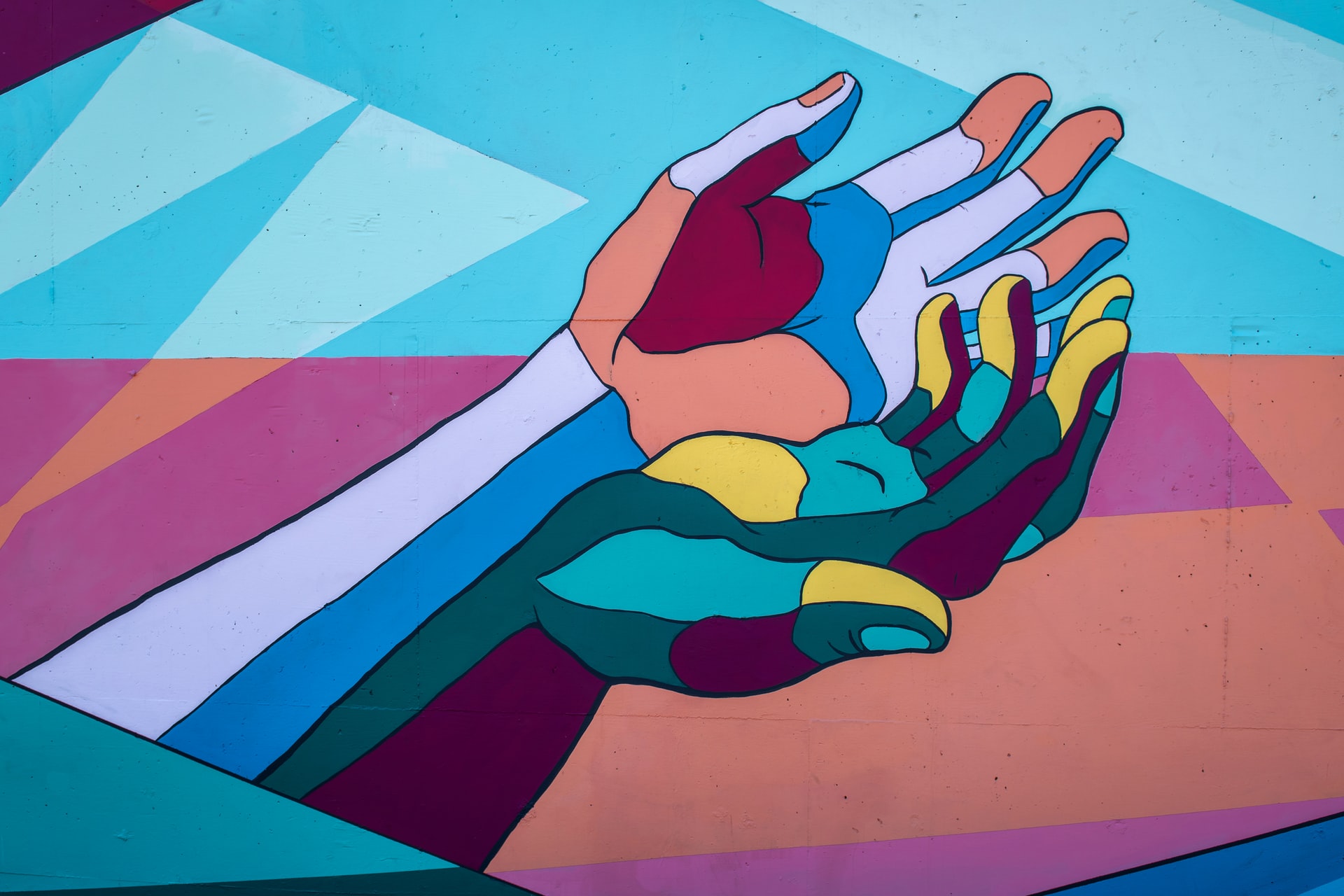 Mural with two hands close together that depict the inclusive culture